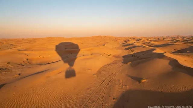 The balloon's shadow stretched across the dunes