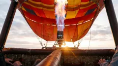 Close-up of the burner flame lighting the pre-dawn sky during inflation
