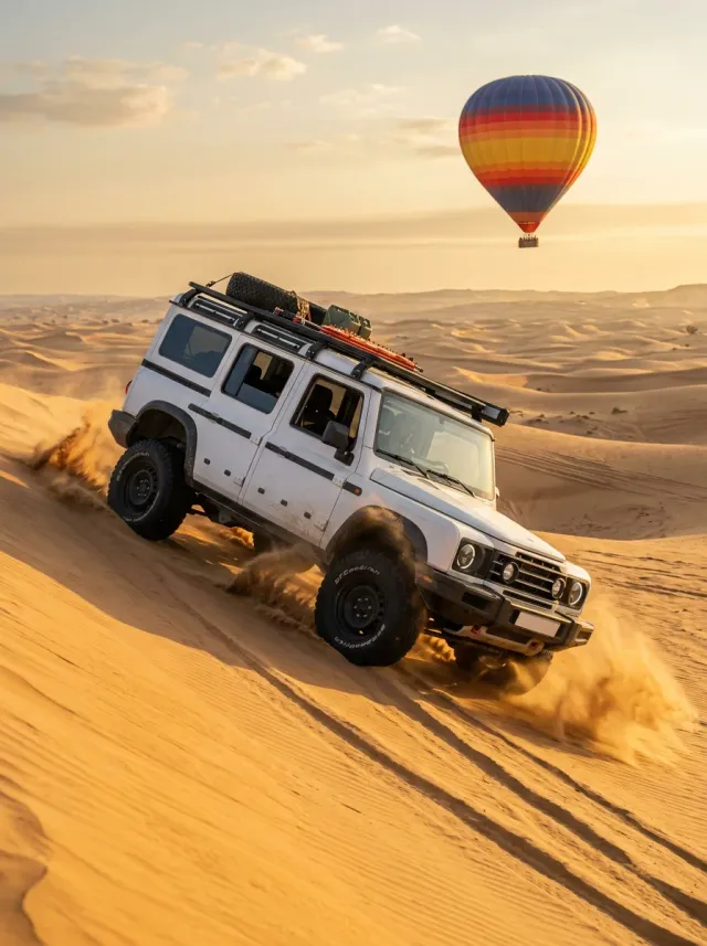 White 4x4 dune bashing with a hot air balloon in the sky behind