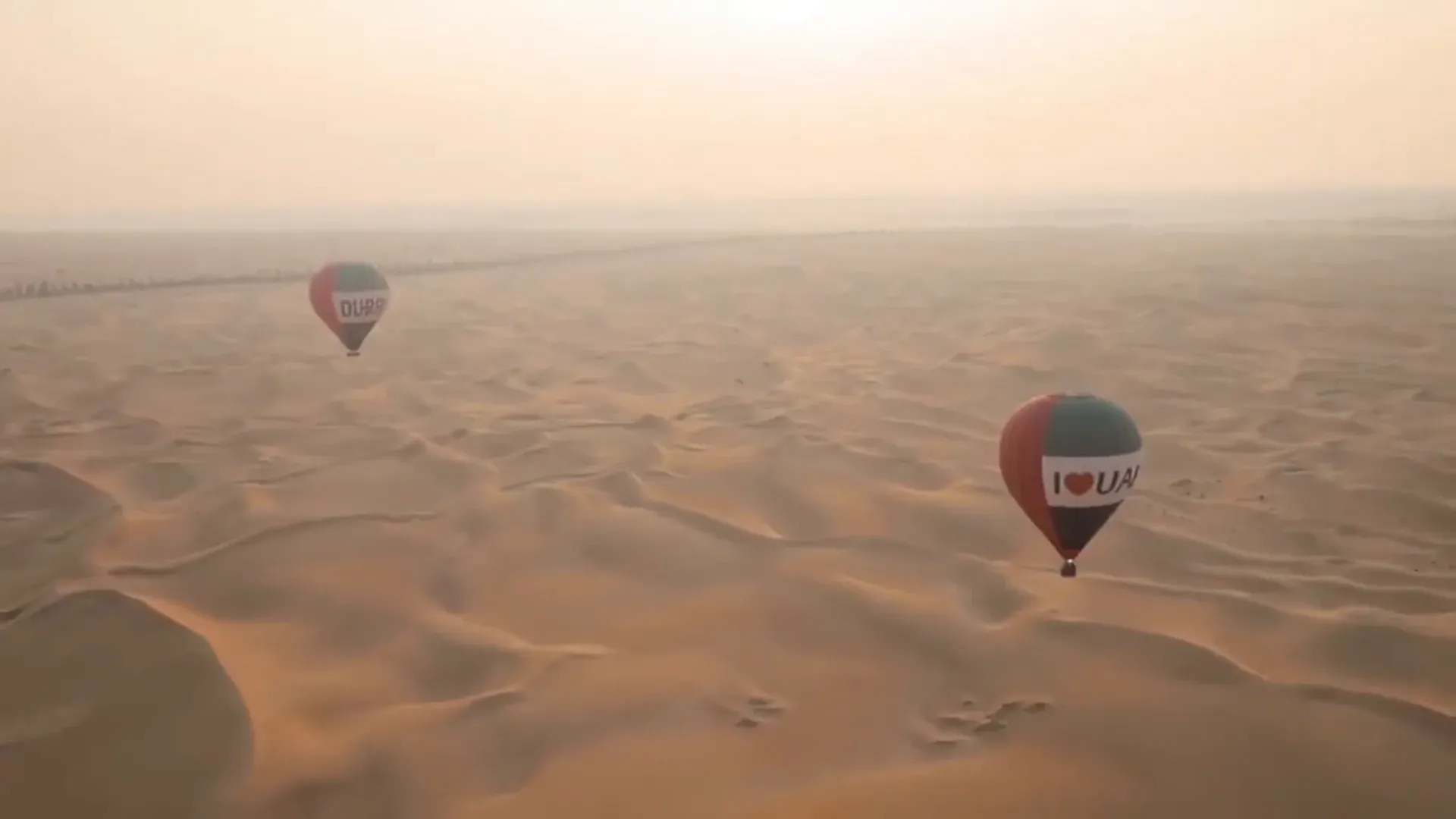 Hot air balloon over the Dubai desert dunes at sunrise