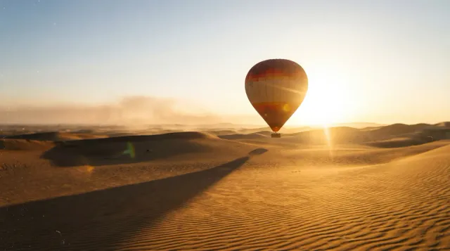 Hot air balloon over the Dubai desert dunes at sunrise