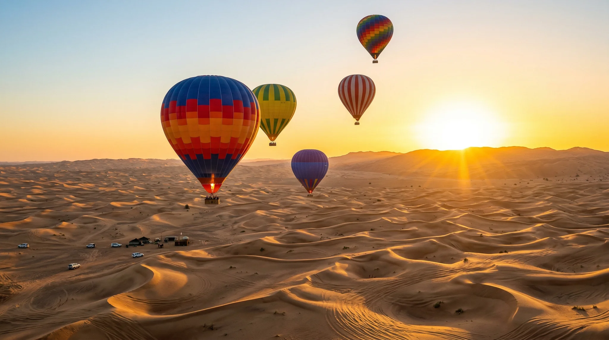 Multiple colorful hot air balloons over Dubai desert at sunrise